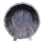 Rangement pour stocker le bois de chauffage, fabriqué à partir d'un tonneau en bois de chêne.