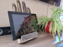 Support pour tablette en bois en style vintage posé sur une étagère à côté d'une plante.